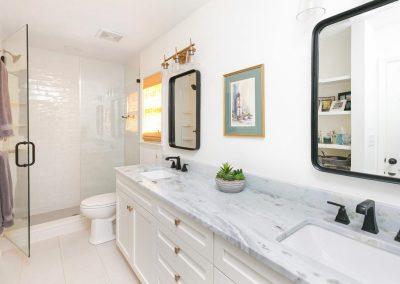 Remodeled bathroom with walk-in shower, double vanity and custom hardware, lighting and mirrors.
