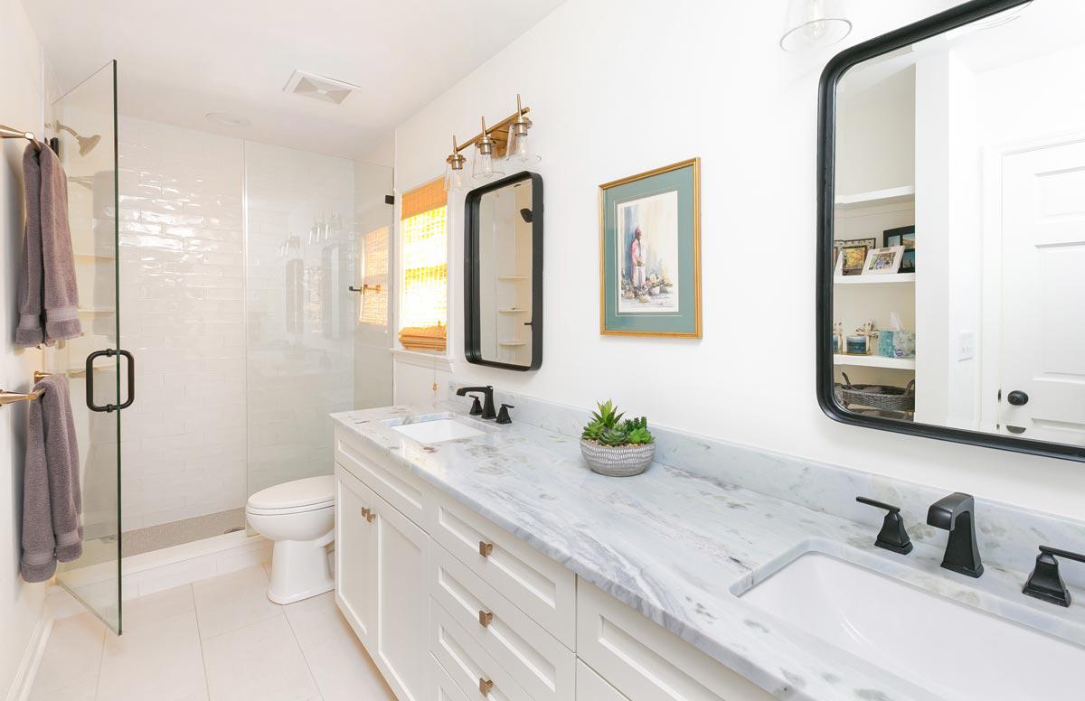 Remodeled bathroom with walk-in shower, double vanity and custom hardware, lighting and mirrors.