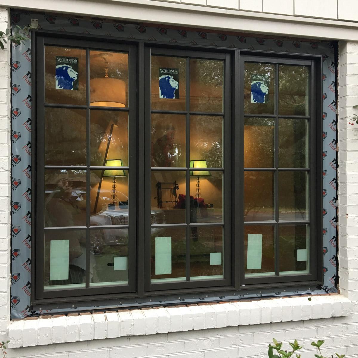New large 3 section window laid in sash with flashing and seen from the outside.