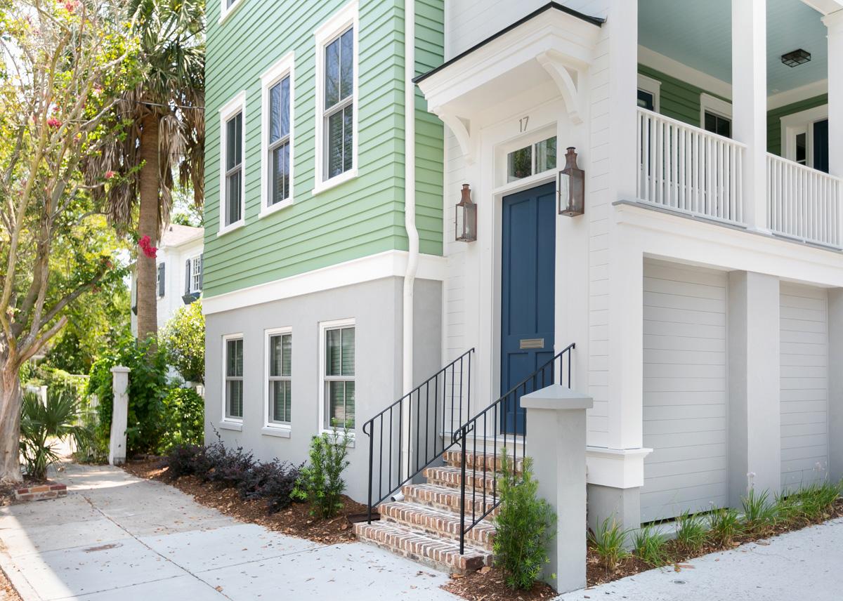 Charleston row house with classic entry, brick steps, landscaping and custom lighting elements.