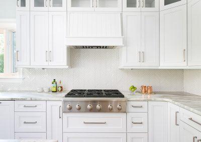 Pristine white renovated kitchen. crown moulding, wide plank flooring and gas range.