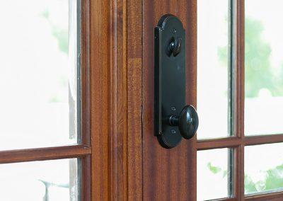 Dark stained front doors zoomed in at beautiful hadware and glass detail.