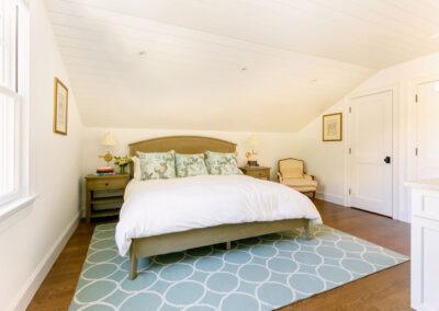 Spacious bedroom with shiplap ceiling detail and recessed lighting.