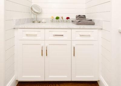 Alcove cabinet tucked into shiplap with marble slab countertop.