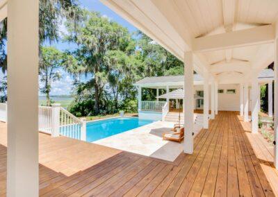 Scenic view of a pool deck, pool in middle ground and majestic oaks and river in the distance.