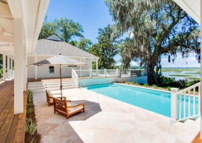 Tiled pool patio and sweeping marsh and river views under a grand virginia live oak.
