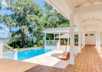 Scenic view of a pool deck, pool in middle ground and majestic oaks and river in the distance.
