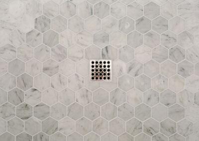 Honeycomb hexagon tile with shower drain beautifully set.