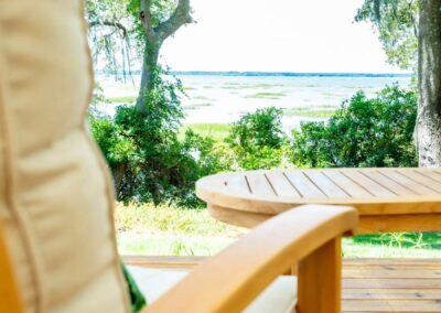 Breathtaking marsh view from the arm of a teak armchair on wooden deck.