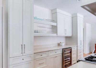 Kitchen range hood and gas range with custom cabinetry and open shelving.