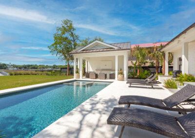 Pool deck and covered patio at waterfront home.