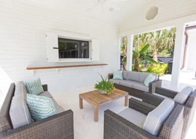 Outdoor living on custom tiled patio with shiplap, built-in tv cabinet and outdoor furnishings.