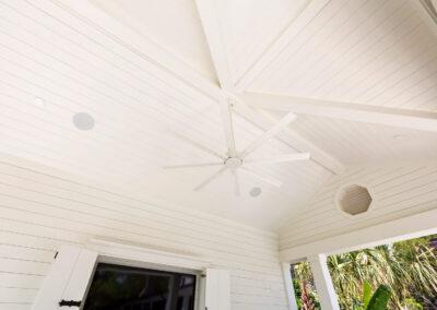 Vaulted ceiling painted white with ship lap and modern ceiling fan on outside deck.