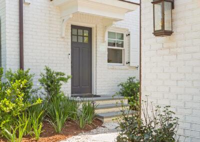 White brick home with custom landscaping and high end features.