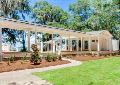 View from side yeard of the back side of pool deck and covered walkway from main house to pool house.