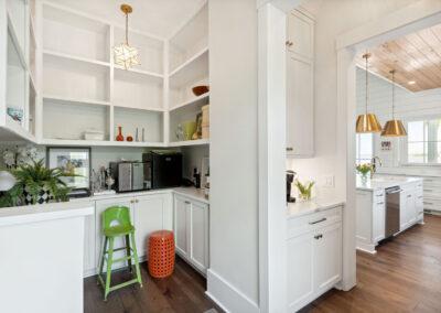 Custom pantry with cabinetry, storage and a view into kitchen.