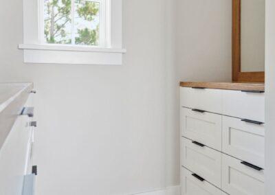custom closet with white cabinetry and warm wood accents.