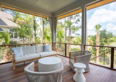 Screened in porch with marsh in background. Modern coastal inspired furnishings.