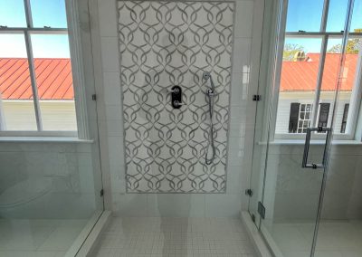 Glass-enclosed stall shower centered in a newly remodeled bathroom in a historic Charleston home.
